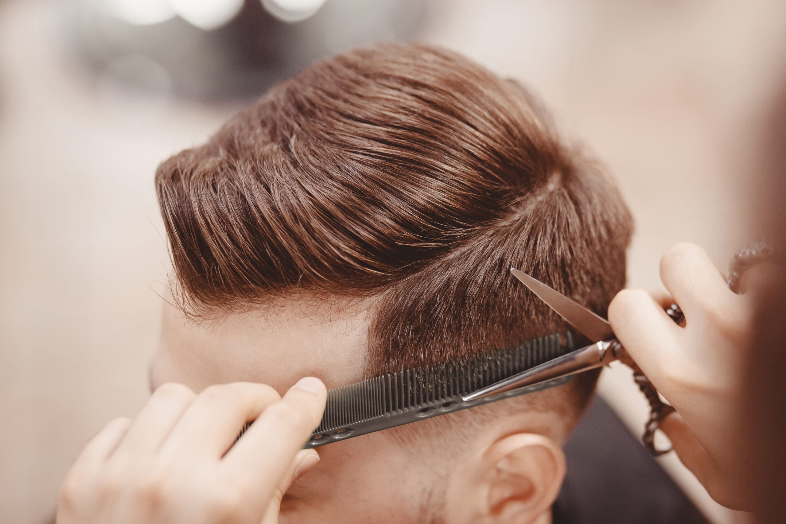 Close-up Master Hairdresser Close up of a barber using scissors and a comb.